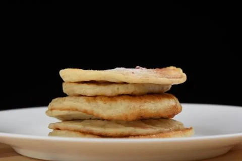 A stack of oatmeal pancakes in a white plate over a wooden background, opposite Stock Photos