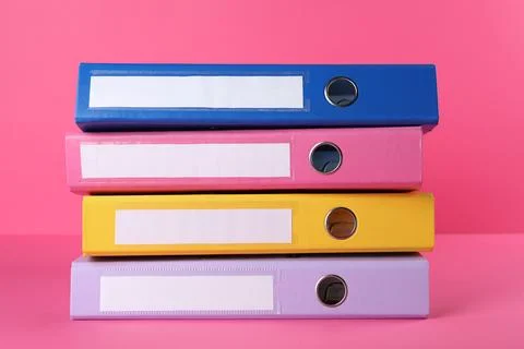 Stack of office folders on pink background Foto stock