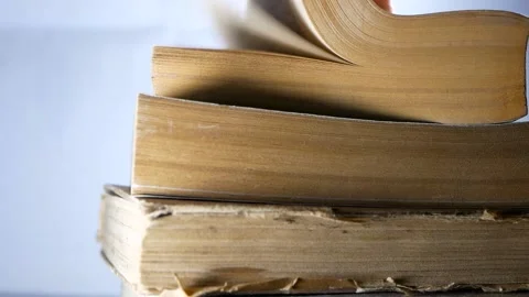 Stack of old aged books, man hand turning the book pages Stock Footage 146226064