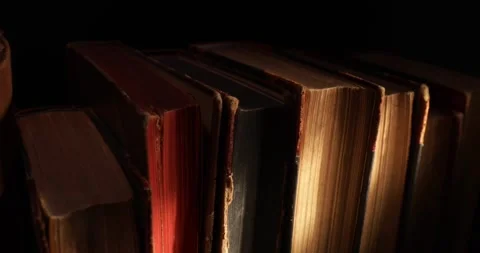 Stack of old antique books in a ray of light. Video stock 311706918