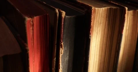 Stack of old antique books in a ray of light. Video stock 311706943