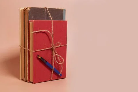 A stack of old battered books tied with a jute rope and a fountain pen Stock Photos