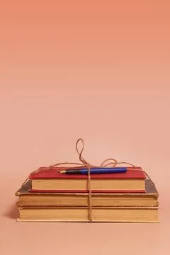 A stack of old battered books tied with a jute rope and a fountain pen Stock Photos