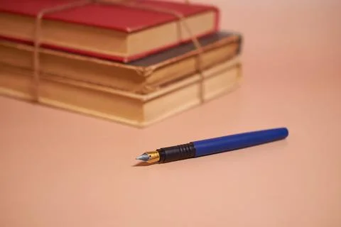 A stack of old battered books tied with a jute rope and a fountain pen Stock Photos
