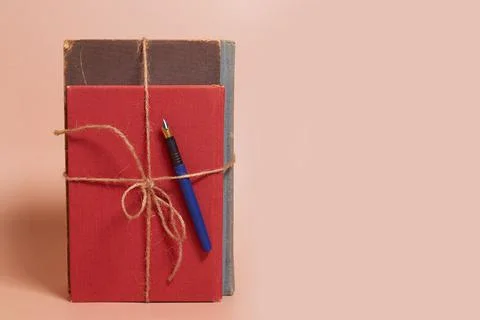 A stack of old battered books tied with a jute rope and a fountain pen Stock Photos