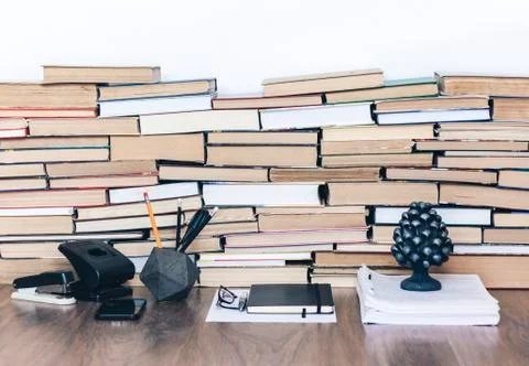 Stack of old book on wooden table, notebook, smartphone, stationery and paper Stock Photos
