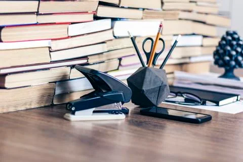 Stack of old book on wooden table, notebook, smartphone, stationery and paper Stock Photos