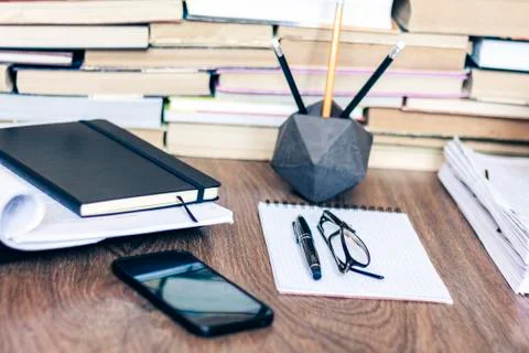 Stack of old book on wooden table, laptop computer, notebook, smartphone, sta Stock Photos