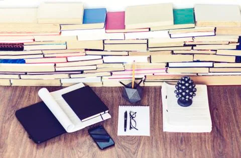 Stack of old book on wooden table, laptop computer, notebook, smartphone, sta Stock Photos
