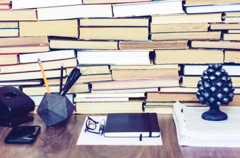 Stack of old book on wooden table, notebook, smartphone, stationery and paper Stock Photos