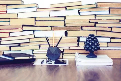 Stack of old book on wooden table, laptop computer, notebook, smartphone, sta Stock Photos