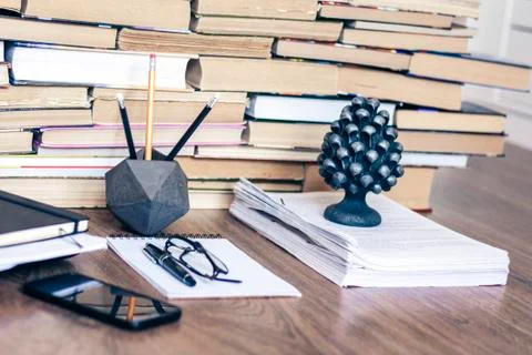 Stack of old book on wooden table, laptop computer, notebook, smartphone, sta Stock Photos
