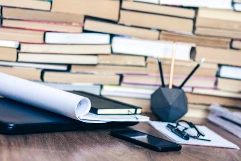Stack of old book on wooden table, laptop computer, notebook, smartphone, sta Stock Photos
