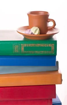 Stack of Old books and a cup of coffee isolated on white Stockfoto's