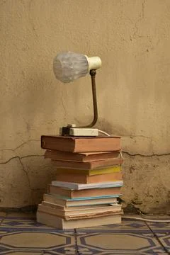 Stack of old books and a lamp Stock Photos
