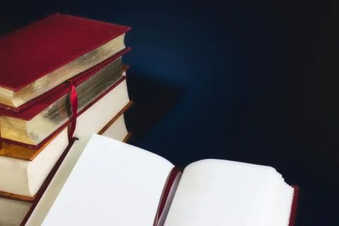 Stack of old books and an open book with blank empty pages Stock Photos