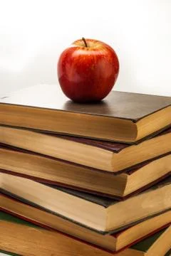 Stack of old books with an apple on top Stock Photos
