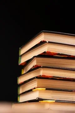 Stack of old books on a black background. Wisdom and knowledge, love of reading. Stock Photos