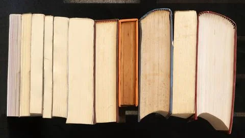 A stack of old books on a black background. Stock Photos