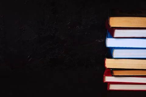 Stack of old books. Black stone background. Stock Photos