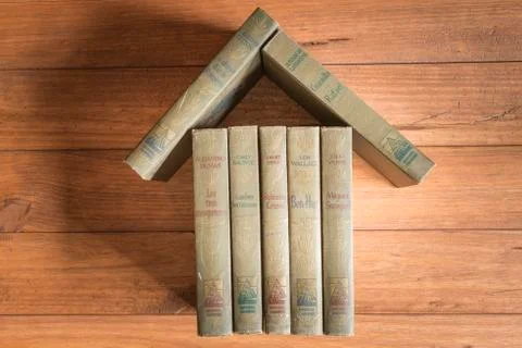 Stack of old books forming the figure of a house. Stock Photos