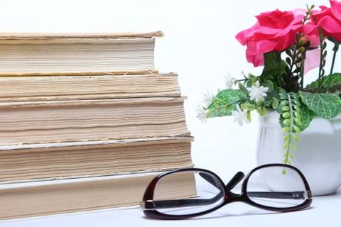 Stack of old books. glasses and flowers in pot Stock Photos