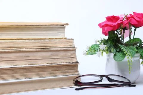 Stack of old books. glasses and flowers in pot Stock Photos
