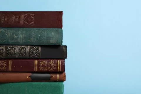 Stack of old books on light blue background, space for text 스톡 사진