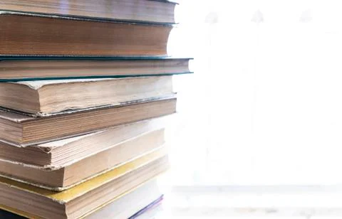 A stack of old books lying on a windowsill Stock Photos