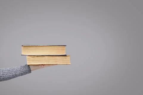 Stack of old books in the palm of an invisible person Stock Photos