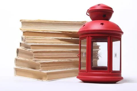 Stack of old books. red lamp with candle Stock Photos