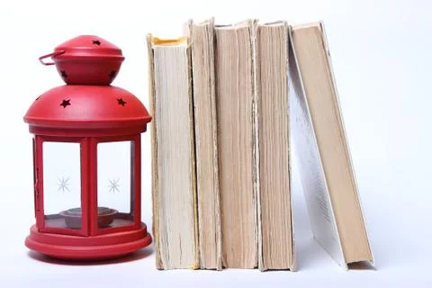 Stack of old books. red lamp with candle Stock Photos