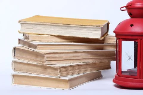 Stack of old books. red lamp with candle Stock Photos