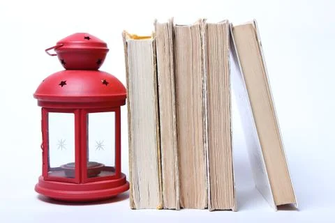 Stack of old books. red lamp with candle Stock Photos