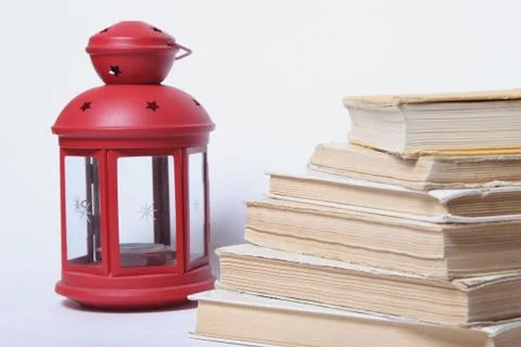 Stack of old books. red lamp with candle Stock Photos