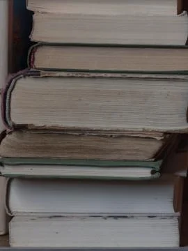 A stack of old books on the shelf. Texture pages of old books close up Stock Photos