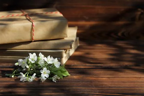 A stack of old books on a wooden background with a sprig of a flowering tree 스톡 사진