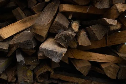 Stack of old chopped dry firewood under a canopy. Firewood stacked in a neat Stock Photos