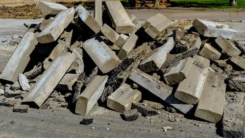 Stack of old concrete curbs removed from street during roadworks, constructio Stock Photos