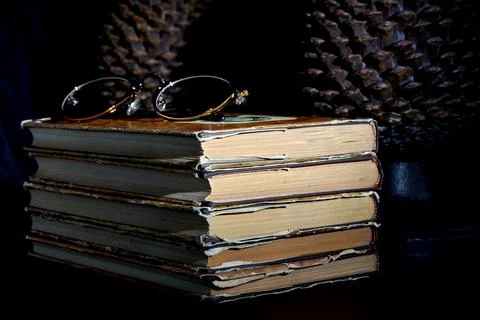 Stack of old dusty books, glasses and book holders Foto stock