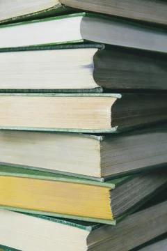 A stack of old hard cover books, with worn edges and paper that is stained or Stock Photos