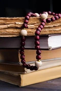 Stack of old holy books and rosary. Stock Photos