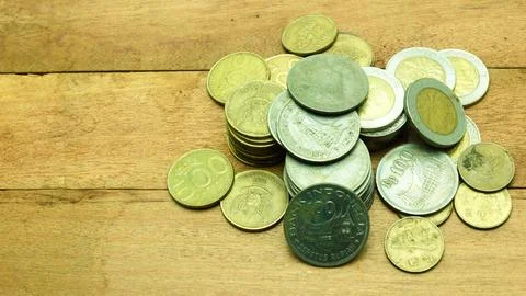 Stack of old Indonesian rupiah coins of various denominations on wood backg.. Stock Photos