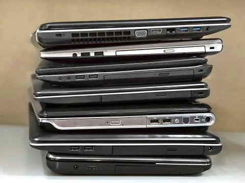 Stack of old laptops awaiting repair Stock Photos