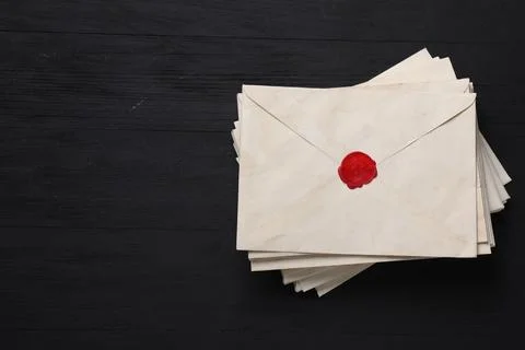 Stack of old letter envelopes on black wooden table, top view Foto stock