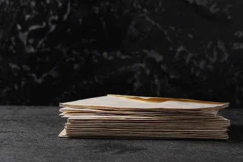Stack of old letter envelopes on grey table Foto stock