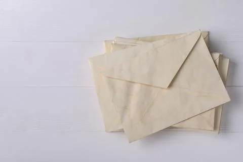 Stack of old letter envelopes on white wooden table, top view. Space for text Foto stock