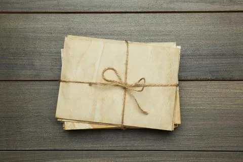 Stack of old letters tied with twine on wooden table, top view 스톡 사진