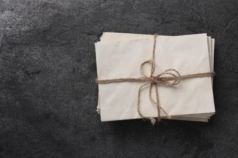 Stack of old letters tied with twine on grey table, top view. Space for text Stock Photos