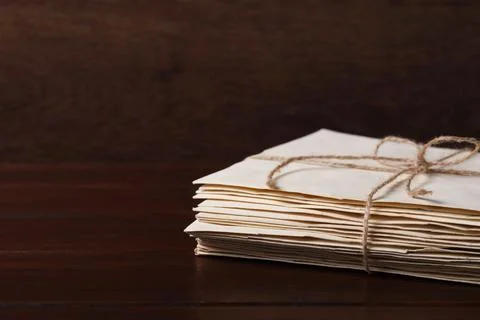 Stack of old letters tied with twine on wooden table, closeup. Space for text Stock Photos
